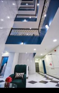 una sala de estar con una silla verde y techos azules en عنوان التميز غرفتين نوم بدخول ذاتي, en Dammam