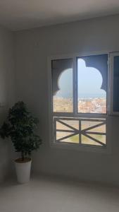 una ventana con una maceta delante de ella en عنوان التميز غرفتين نوم بدخول ذاتي, en Dammam