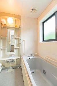 a bathroom with a tub and a sink and a window at Farm Inn Neba - Vacation STAY 46695v in Urugi