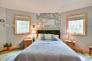 um quarto com uma cama grande e 2 janelas em Enchanting Shelby Cottage on 12 Acres and Hot Tub! em Shelby