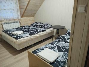 - 2 lits dans une petite chambre avec une table dans l'établissement Pokoje z łazienkami nad Jeziorem Serwy, à Mołowiste