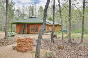 una cabaña en el bosque con un montón de troncos delante en Enchanting Shelby Cottage on 12 Acres and Hot Tub!, en Shelby