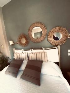 ダシアにあるLas plantas-studios-apartments-Corfuのベッドの上に鏡が3つあるベッドルーム