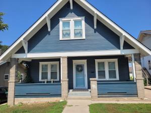 niebieski dom z białym oknem w obiekcie The Hamilton House Loft w mieście Omaha