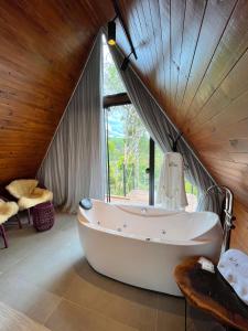 a large bath tub in a room with a window at Pousada Cabanas Araxá in Urubici