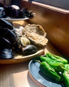 um prato de mexilhões e um prato de produtos hortícolas numa mesa em Péniche Anna Maria 4 em Sète