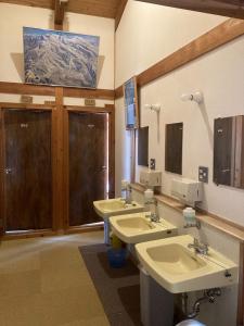 Zao Pension Aramiya - Vacation STAY 40314v في Kaminoyama: حمام بثلاث مغاسل ومرايا