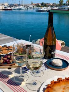 una mesa con copas de vino y una botella de vino en Péniche Anna Maria 4, en Sète