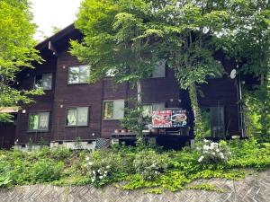una casa in legno con un cartello di fronte di Zao Pension Aramiya - Vacation STAY 40314v a Kaminoyama