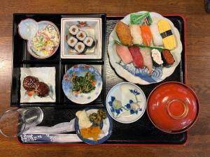 Zao Pension Aramiya - Vacation STAY 40314v في Kaminoyama: صينية مع أطباق من الطعام على طاولة