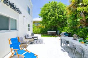 - un ensemble de chaises et de tables sur une terrasse dans l'établissement Dog friendly condo with beach access, hot tub, firepit, à West Palm Beach