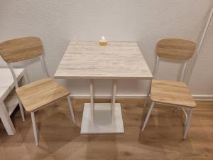 una mesa de madera con 2 sillas y una mesa en Monteur Apartment Schelklingen Biosphärenreservat en Schelklingen