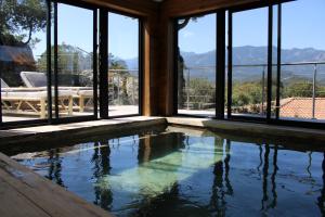 - une piscine dans une maison avec fenêtres dans l'établissement A Camerina, à Sotta