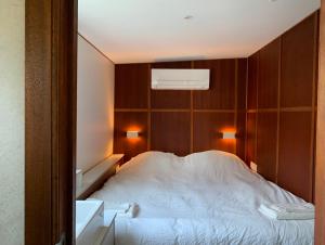 a bedroom with a large white bed with wooden walls at Péniche Anna Maria 4 in Sète