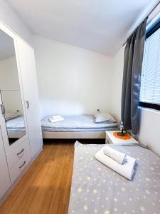 una piccola stanza con due letti e uno specchio di 3-Bedroom Apartment With Panoramic Bay Views a Kotor (Cattaro)