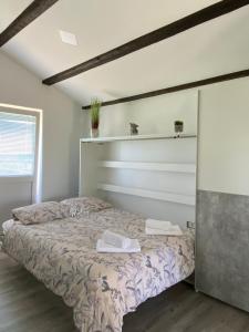 een slaapkamer met een bed met twee handdoeken erop bij Apartma Vista Baredi in Izola