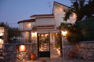une maison blanche avec un portail et des lumières dans l'établissement Athina's Villa, à Koskinou