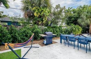 eine Terrasse mit blauen Tischen und Stühlen sowie einem Grill in der Unterkunft Dog friendly condo with beach access, hot tub, firepit in West Palm Beach