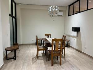 een eetkamer met een tafel en stoelen en een kroonluchter bij Studio 69 Aparthotel in Iquitos