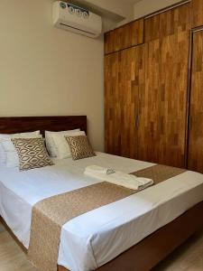 1 dormitorio con 1 cama grande y cabecero de madera en Studio 69 Aparthotel, en Iquitos