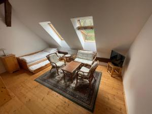 an attic room with a bed and a table and chairs at Hájovna u Jezerního potoka in Nová Pec