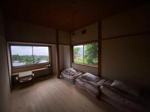 an empty room with two beds and two windows at Togaku Hokosha - Vacation STAY 15767 in Nagano