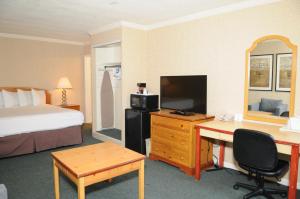 a hotel room with a bed and a desk with a computer at Civic Center Motor Inn in San Francisco