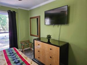 a bedroom with a dresser with a television on the wall at 6BR in Suburban area close to Freeway and Galeria in Memphis