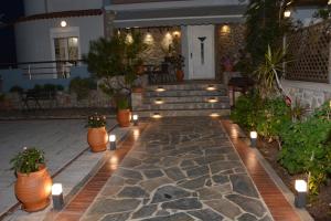 une terrasse avec des bougies et des plantes en pot en face d'une maison dans l'établissement Athina's Villa, à Koskinou