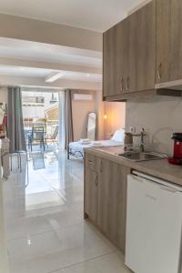 a kitchen with wooden cabinets and a living room at Levanda Luxury Studios Apartments in Nydri