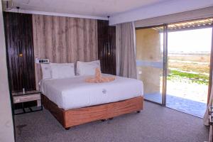 a bedroom with a large bed and a large window at Riverfront Resort and Camping in Shakawe