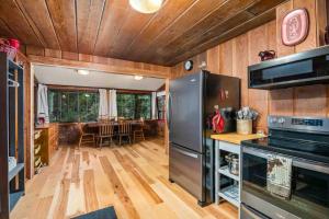 a kitchen with a stainless steel refrigerator and a dining room at Cedar Camp in Welches