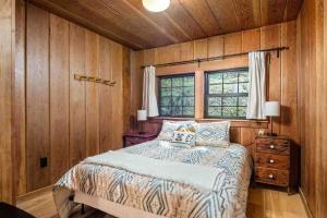 a bedroom with a bed with a wooden wall at Cedar Camp in Welches