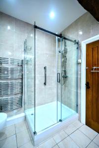 a bathroom with a shower with a glass door at Renovated 5 Bedroom Farmhouse in Picturesque Eskdale, Lake District in Eskdale