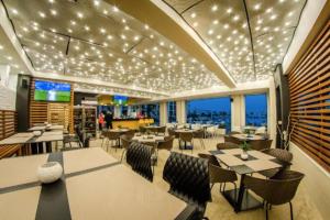 a restaurant with tables and chairs and lights at Premier Fort Apartment on Seafront in Sveti Vlas