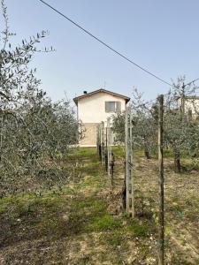 ein Haus hinter einem Zaun in einem Apfelgarten in der Unterkunft Casa Stefano in Spoleto