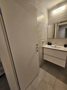 a white bathroom with a sink and a mirror at צ'יל ורוגע עם ג'קוזי וגינה פרטית in Bayit Wegan