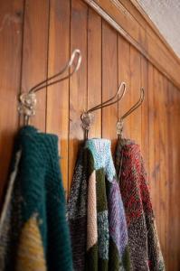 three towels are hanging on a wooden wall at Casa Fratomari - the Alpine dream in Lombro