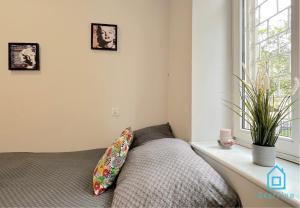 a bedroom with a bed with a pillow and a window at Monroe Room in Gdańsk