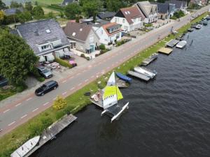 a small sail boat in the water next to a street at B&B Schiphol Amsterdam in Rijsenhout