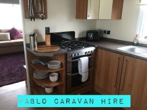 a kitchen with a stove and a counter top at 3 Bedroom 8 Berth Caravan Towyn in Rhyl