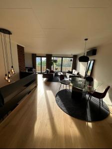 een woonkamer met een bank en een tafel en stoelen bij Newly Renovated Centrum House with Large Balcony in Haugesund