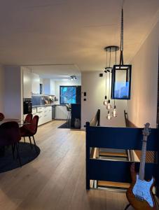 een woonkamer en eetkamer met een blauwe gitaar bij Newly Renovated Centrum House with Large Balcony in Haugesund
