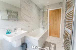 a white bathroom with a sink and a mirror at Luxury 3 Bed Apartment, Private Parking BHX JLR NEC HS2 in Solihull