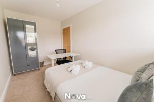 a bedroom with a white bed and a desk at Luxury 3 Bed Apartment, Private Parking BHX JLR NEC HS2 in Solihull