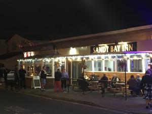 a group of people standing outside a restaurant at night at 3 Bedroom 8 Berth Caravan Towyn in Rhyl