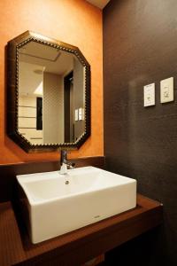 W łazience znajduje się biała umywalka i lustro. w obiekcie "1st STEP HOTEL" - Vacation STAY 93790v w Tokio