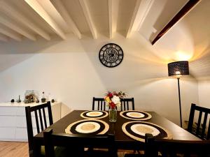 a dining room table with chairs and a clock on the wall at Luxury Suites Centrum by Rikas Hotels in Antwerp