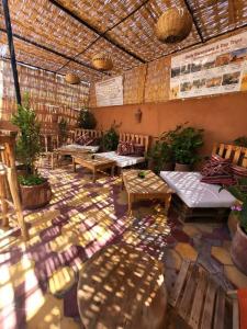 Zimmer mit Tischen, Stühlen und einer Decke in der Unterkunft Medina Oasis Hostel in Marrakesch