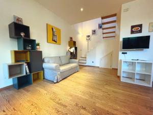 a living room with a couch and a television at Loft Casa EGLi in Florence